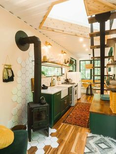 a kitchen and living room are shown in this house with wood floors, green cabinets, and an open floor plan