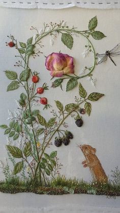 an embroidered wall hanging with flowers, berries and a dragonfly on it's side