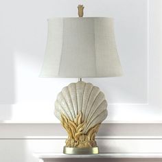 a lamp that is sitting on top of a table in front of a wall with white walls