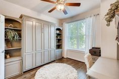 a bedroom with white furniture and a ceiling fan