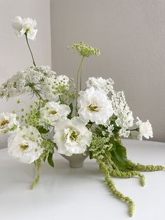 white flowers in a vase on a table