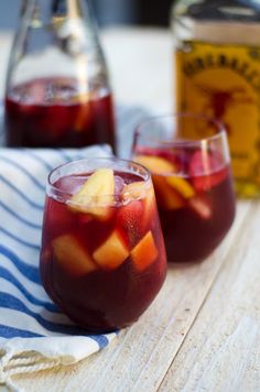 two glasses filled with fruit on top of a table