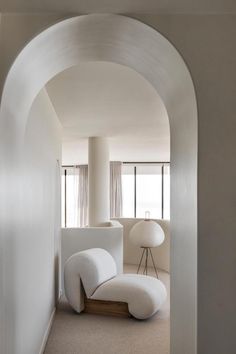 an arch leading into a living room with white furniture