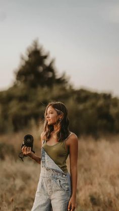 a woman standing in a field with her hair dryer