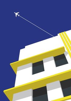 an airplane is flying over the top of a yellow and white building with black windows