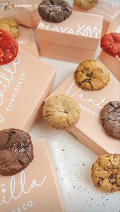 chocolate chip cookies and red velvet cookies are on pink boxes with the words hello written in white