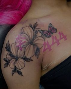 a woman with pink hair has a butterfly and flower tattoo on her shoulder