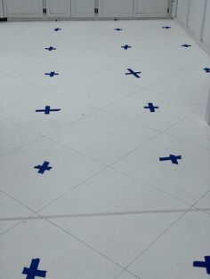 a white tiled floor with blue crosses on it