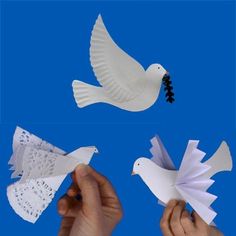 paper birds are being held up by two hands and one is holding a piece of paper