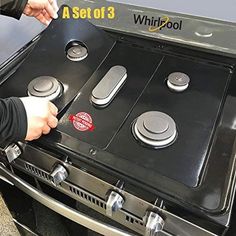 a person is opening the door to an outdoor gas stove that has three burners on it