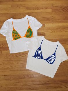 two t - shirts with bras on them are sitting on the floor next to each other