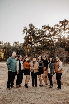 a group of people standing next to each other on top of a dry grass field