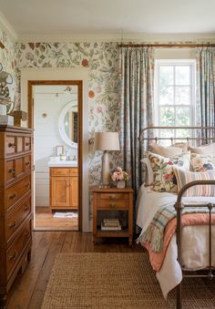 a bed room with a neatly made bed next to a dresser and a large window