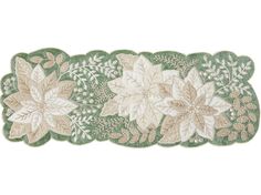 three green and white flowers are on the edge of a table runner, with leaves