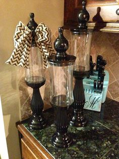 three glass vases with bows on them sitting on a counter