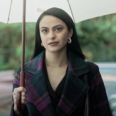 a woman is holding an umbrella in the rain