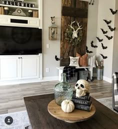 a living room decorated for halloween with skulls, pumpkins and other decorations on the coffee table