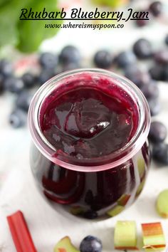 a jar filled with blueberry jam next to sliced apples