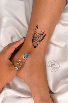 a woman's foot with a butterfly tattoo on it