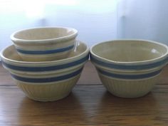 four bowls sitting on top of a wooden table next to each other with blue stripes