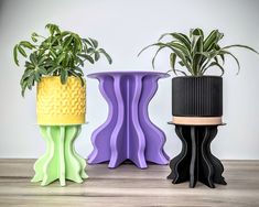 three different colored planters sitting next to each other