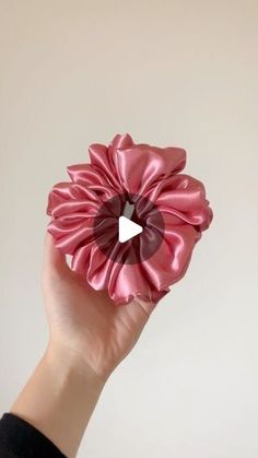 a hand holding a pink flower with a heart in it's center and a white background