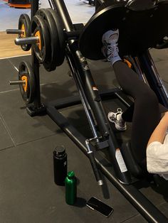 a woman is doing squats on a bench in a gym with an exercise machine