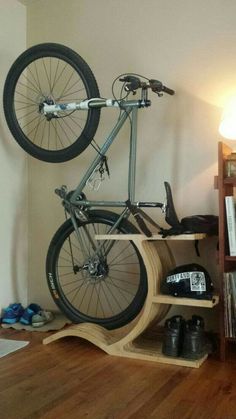 a bicycle mounted to the side of a wooden shelf in a room with hard wood flooring