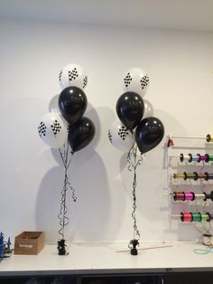 black and white balloons are tied to the wall