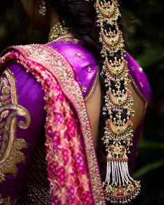 the back of a woman's head with jewelry on her neck and shoulder,