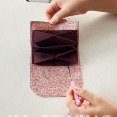 someone is making an origami wallet out of fabric