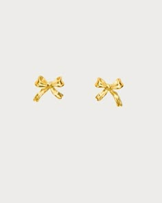 Graced with an enchanting bow motif, these earrings exude the charm and elegance of balletcore aesthetics. Perfect for daily wear, these earrings blend the poise of ballet with a playful, festive spirit, making them an ideal accessory for those who adore a touch of whimsy in their style. Materials: 18k gold plated brass / Platinum plated brass Measurements: 9.35mm/0.37" in width, 7.48mm/0.29" in height Preppy Earrings Classy, Fancy Earrings Gold, Earing Stack Gold, Earrings Aesthetic Gold, Gold Bow Jewelry, Gold Dainty Earrings With Bow, Cute Gold Earrings, Bow Gold Earrings, Bow Earrings Gold