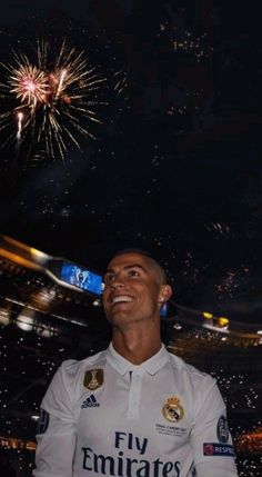 a man standing in front of fireworks with his hand on his hip and looking up at the sky