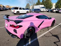 a pink sports car parked in a parking lot