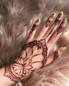 a woman's hand with henna tattoos on it