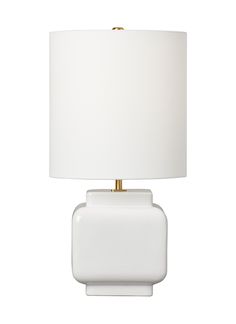 a white lamp with a gold base and a white shade on the top of it