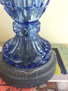 a blue glass vase sitting on top of a table