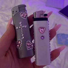 two lighters that are in the palm of someone's hand, one has a heart on it