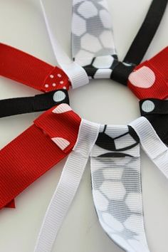 four pieces of ribbon tied to each other on a white surface with red and black ribbons