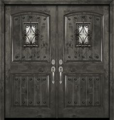 an old style double door with decorative iron work on the top and bottom paneling