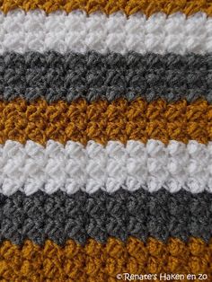 the crocheted blanket is made up of two different shades of gray, yellow and white