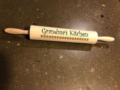 a wooden rolling pin with the words grandma's kitchen written on it