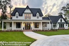 a large white house with lots of windows on it's front porch and driveway