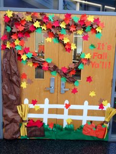 a door decorated with paper leaves and fall decorations on the front entrance to a school