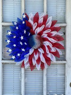 an american flag wreath hanging on the side of a window