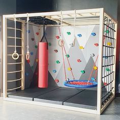 an indoor gym with climbing ropes and a punching bag