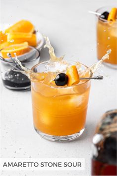 an orange drink is being poured into a glass with some fruit on the rims