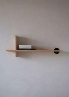 a wooden shelf with books on it and a book holder attached to the wall behind it