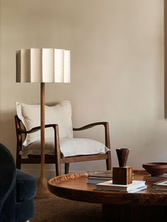 a living room filled with furniture and a lamp on top of a wooden coffee table