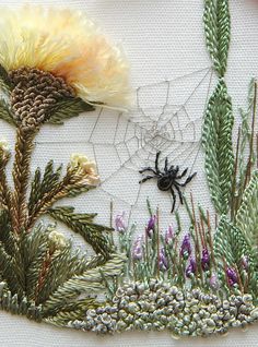 a spider is sitting on the side of a piece of fabric with flowers and grass